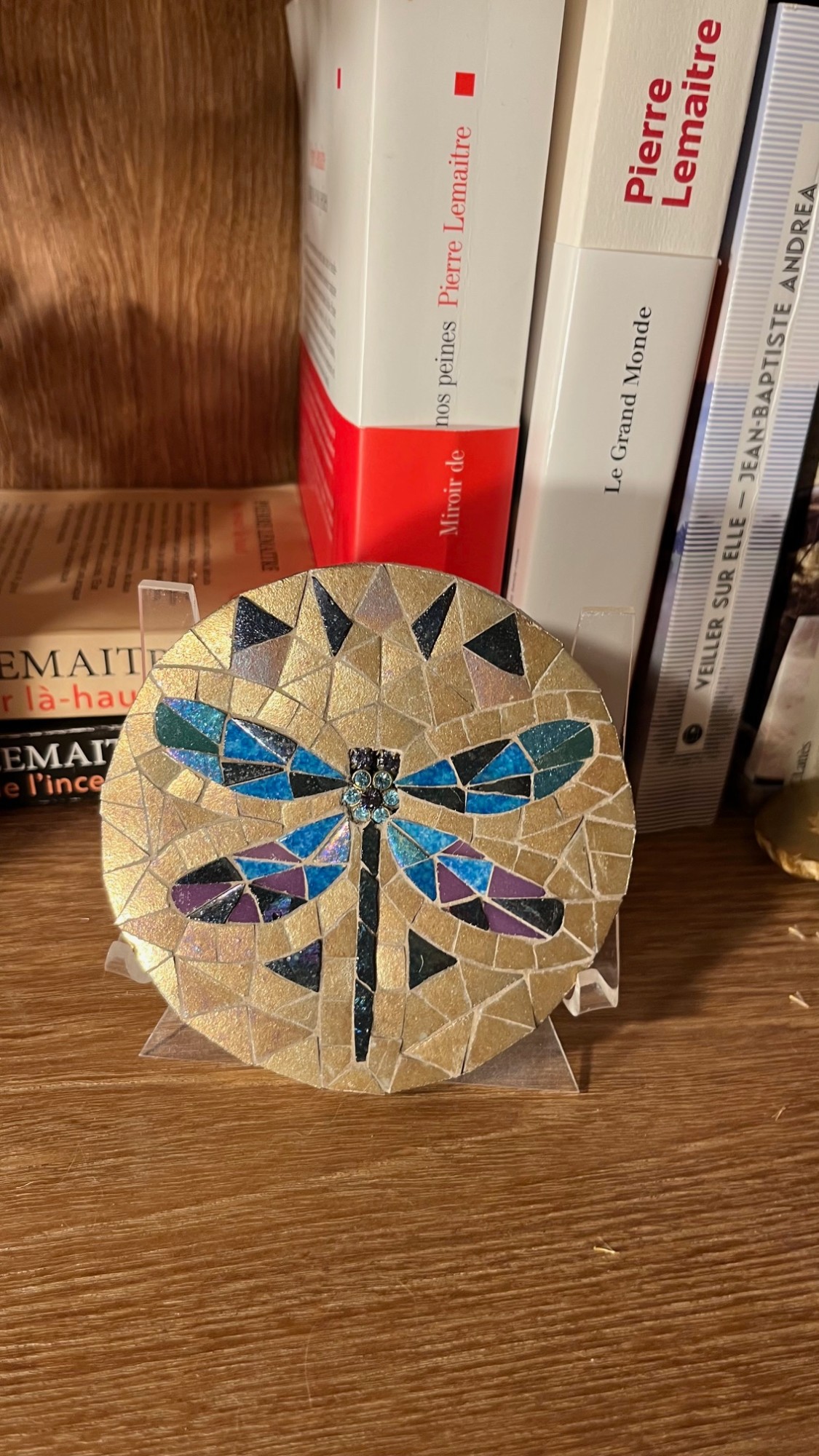 Mosaïque circulaire représentant une libellule bleue et violette sur fond doré